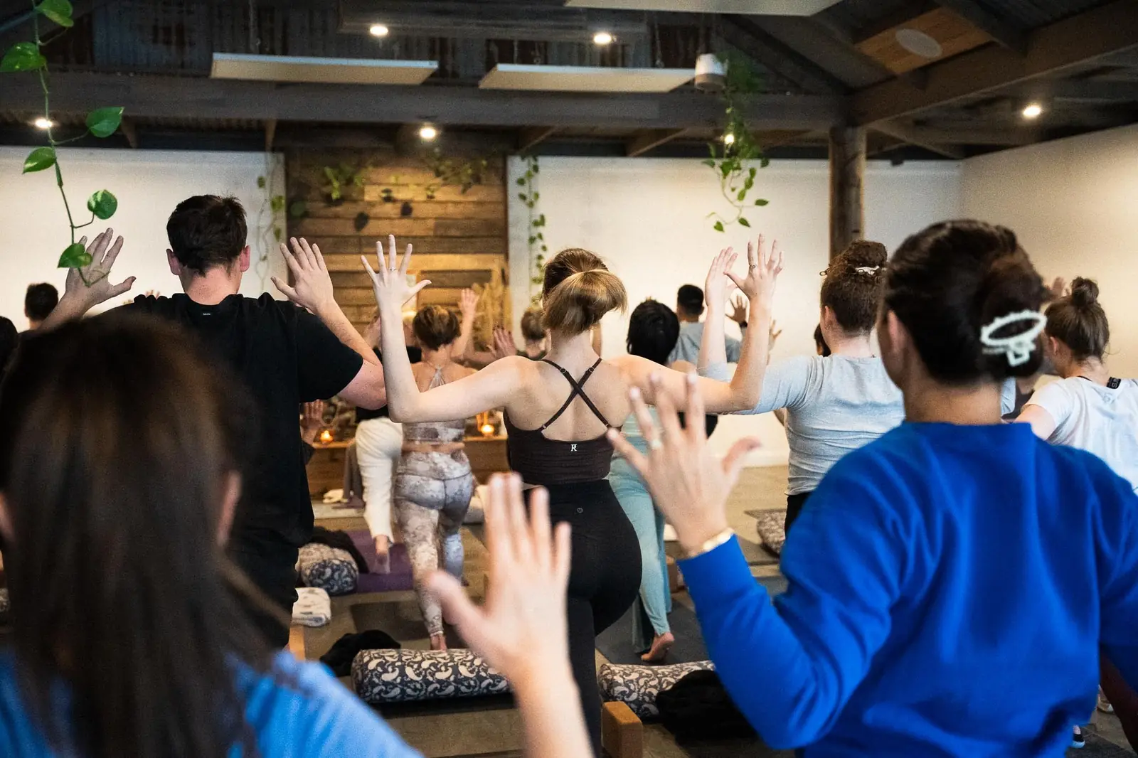 A group practicing yoga together with arms raised