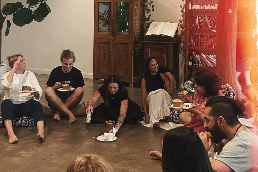 The Om Som community sharing food in a circle