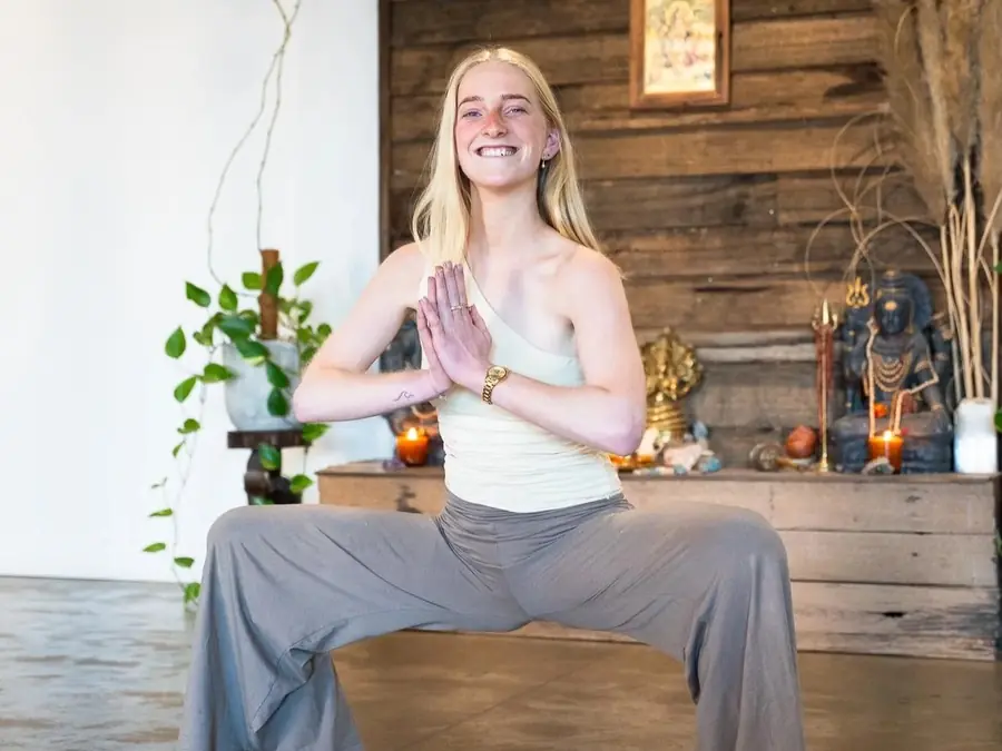 A student in a strong standing pose with hands in prayer