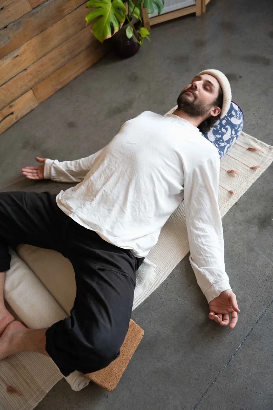 Aaron resting over a bolster in a Yin pose